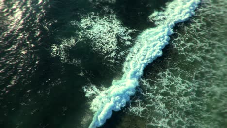 vista aérea de las olas del océano chocando contra la orilla