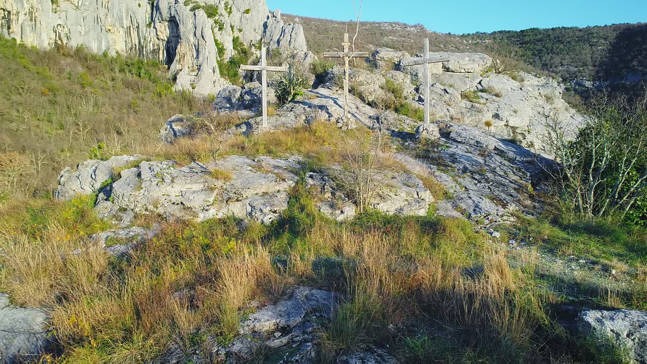 Jib up shot of three wooden crucifixes standing on a rocky mountain in Croatia