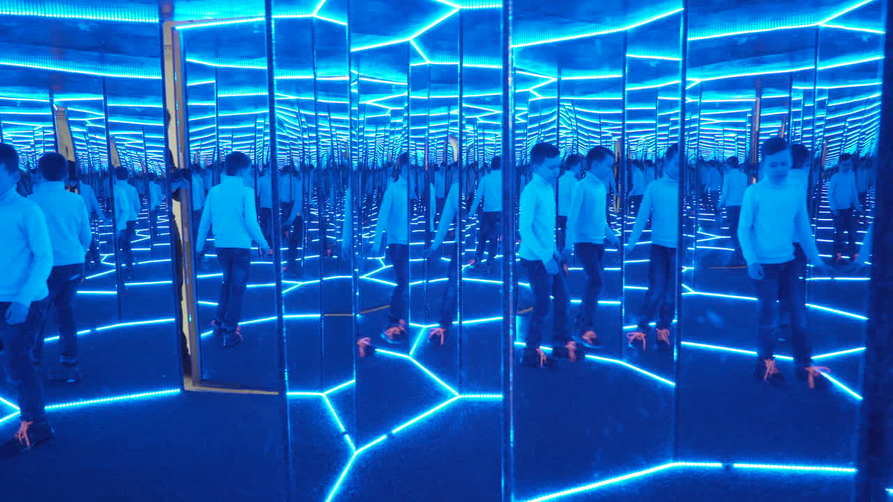 Boy playing with distorted mirror. Museum of entertaining sciences