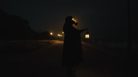man silhouette in the dark halloween night with a bright lantern
