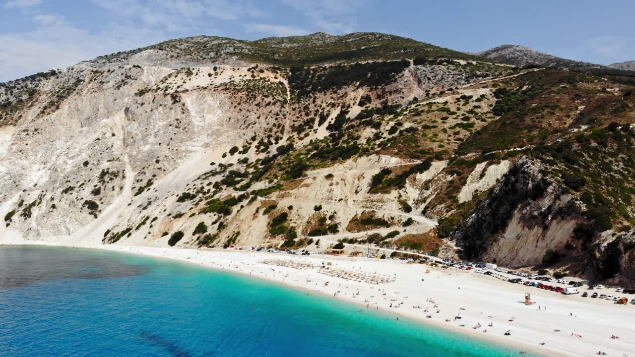 Scenic View Of Myrtos Beach With Mountains, White Sand, And Calm Turquoise Water - aerial drone shot