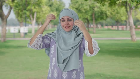 happy muslim woman wearing hijab in park