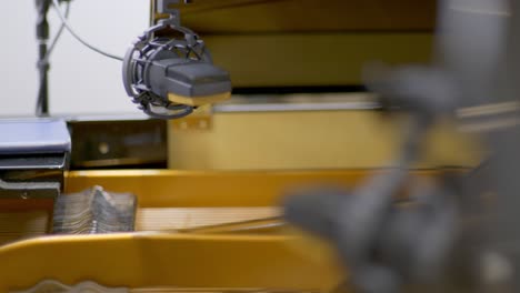 enfoque desgarrador de dos micrófonos de condensador colocados sobre las cuerdas de un piano de cola de concierto abierto en un estudio de grabación