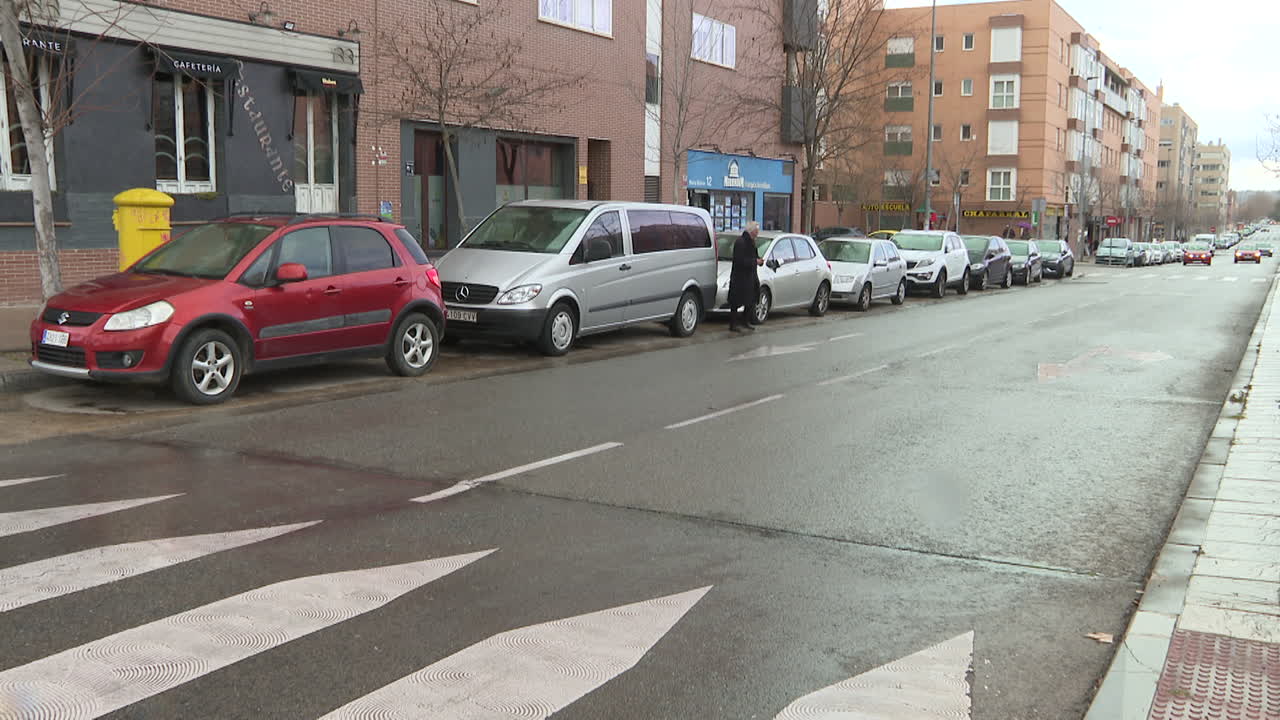 City street scene with parked cars and pedestrian