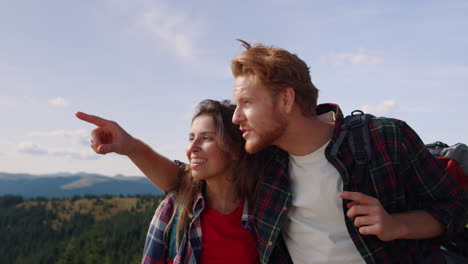 Woman-and-man-looking-at-landscape-on-top-of-mountain