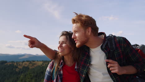 woman and man looking at landscape on top of mountain