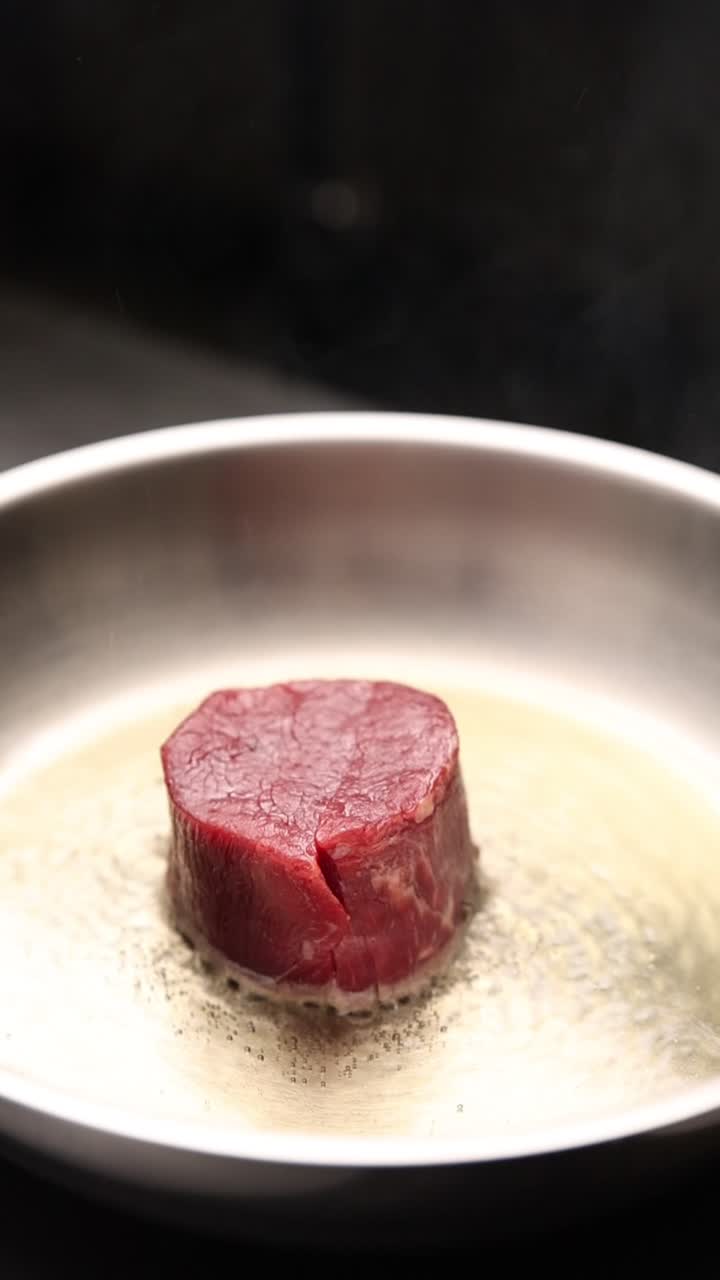 Bistecca cruda che sfrigola in padella con condimento