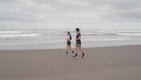 pareja corriendo en la playa