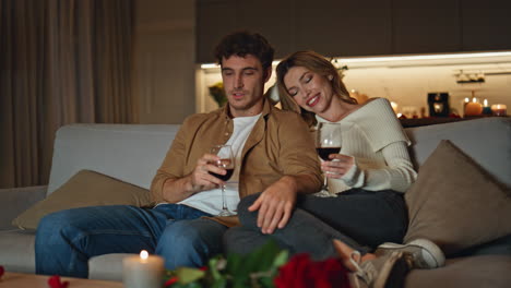 married pair relaxing couch holding wine glasses. spouses enjoying romantic date