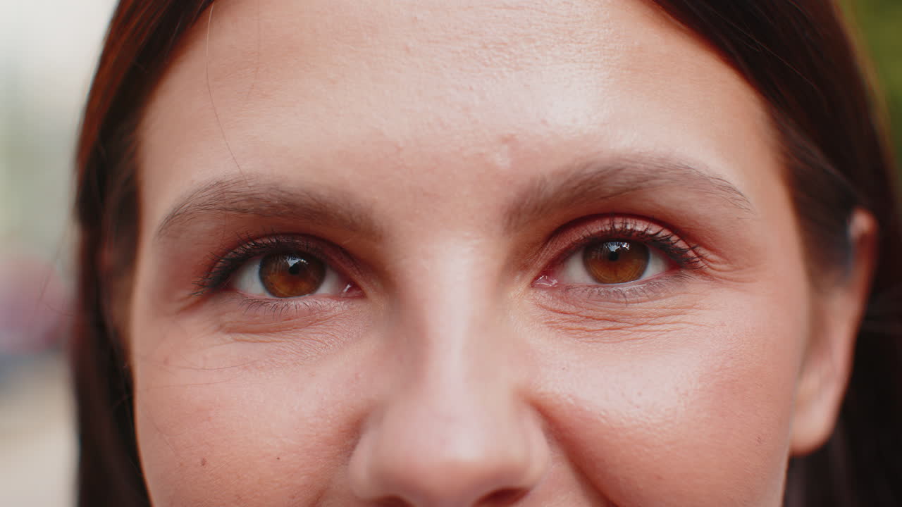 Closeup macro portrait of natural beauty young beautiful womans brown eyes looking at camera