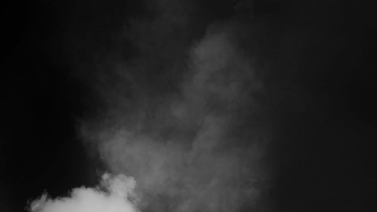 Realistic white smoke or fog slowly billows from bottom left on black background. Use as overlay for atmospheric, moody, or mysterious scenes