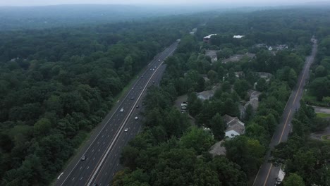 Aerial-footage-of-suburban-subdivision-next-to-suburban-highway-in-the-foggy-morning