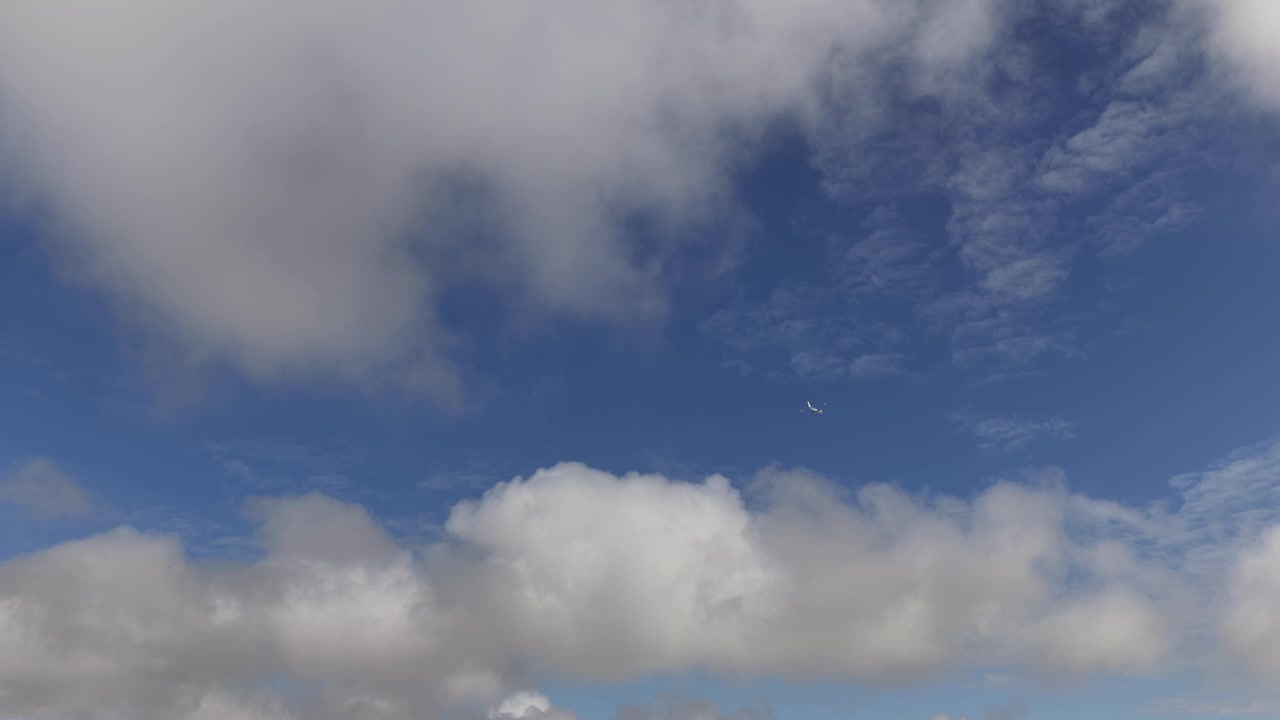 Drone reveal shot of airplane flying in and over the clouds.