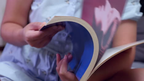 scanning through the pages while reading a colorfully illustrated book