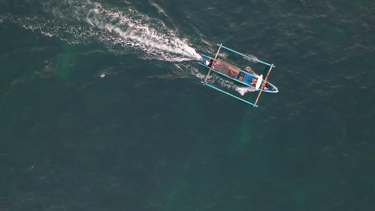 넓은 바다에서 항해하는 전통적인 발리 보트에서 관광객 서퍼
