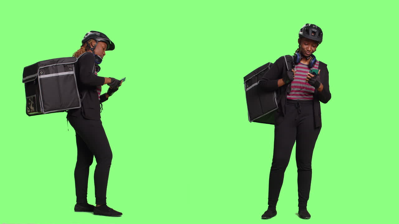 Uma mulher com uniforme de entregador(a) checa o celular