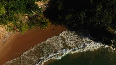 aerial footage of a north-coast bay with waves crashing against the cliffs