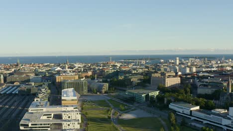 Aerial-reverse-shot-of-Helsinki,-Finland-with-the-Museum-of-Contemporary-Art-Kiasma-and-city-library-in-view