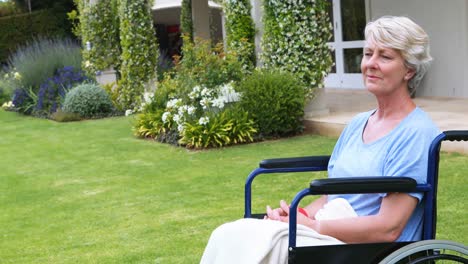 thoughtful senior woman sitting in wheelchair