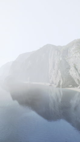 a beautiful aerial view of a rocky coastline with fog