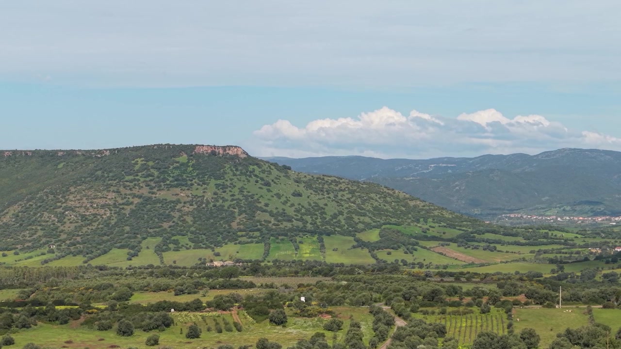 Pemandangan udara area Nuxis di Provinsi Sulcis, Sardinia, Italia, menampilkan bukit pedesaan, pedesaan hijau, vegetasi Mediterania, dan lanskap alam di sekitarnya.