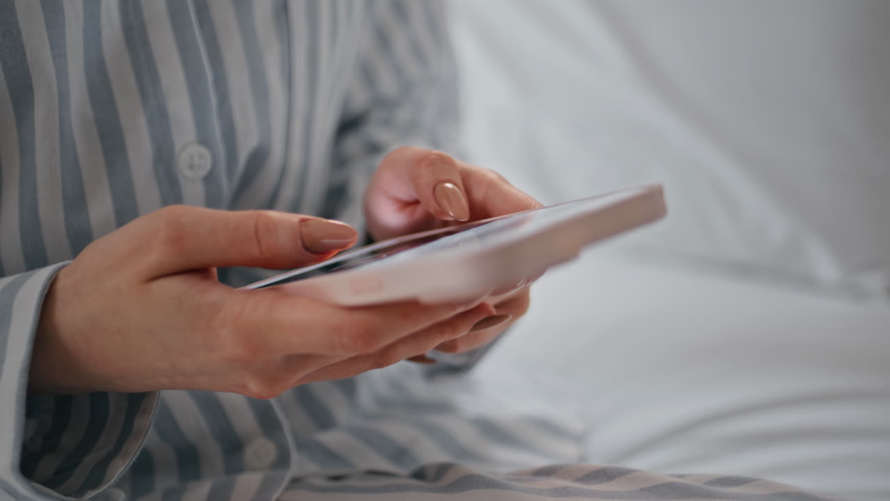 Woman fingers swiping smartphone screen at home morning closeup. Unknown girl