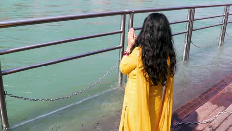 Niña-Aislada-Haciendo-Palanca-En-El-Río-Sagrado-Ganges-En-La-Orilla-Del-Río-Desde-Un-ángulo-Plano-Se-Toma-Un-Video-En-La-Orilla-Del-Río-Ganga-Haridwar-Uttrakhand-India