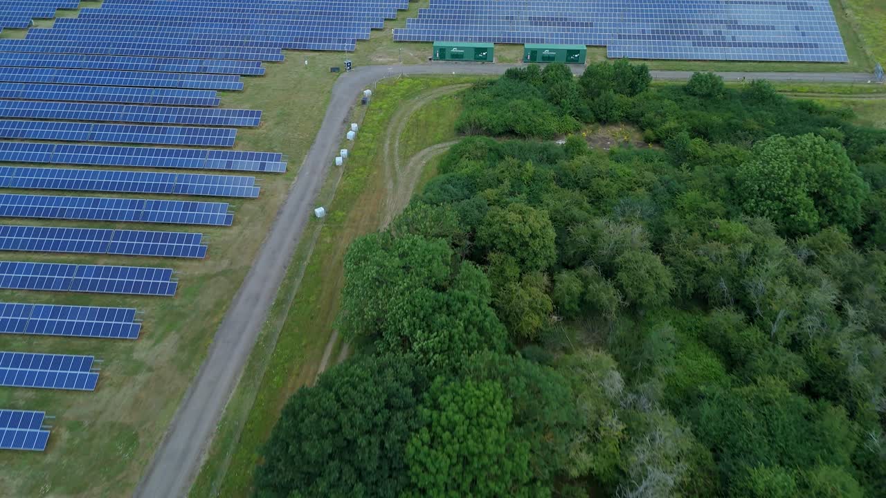 Dynamic Drone aerial Over Solar Energy Facility and Powerlines Supplying Clean Electricity in England UK