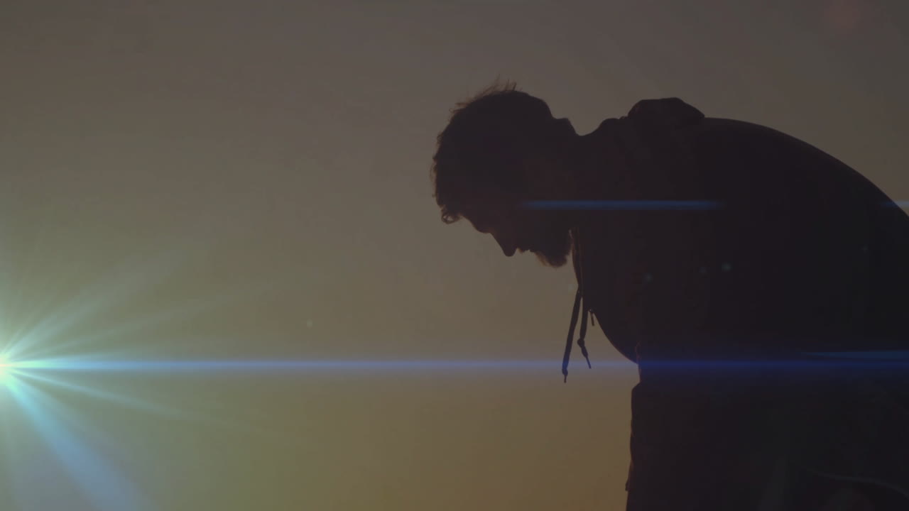 Bending forward, silhouette of person against sunset with lens flare animation