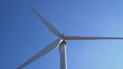 Detail-of-wind-turbine-rotating-around-with-blue-sky---slow-motion