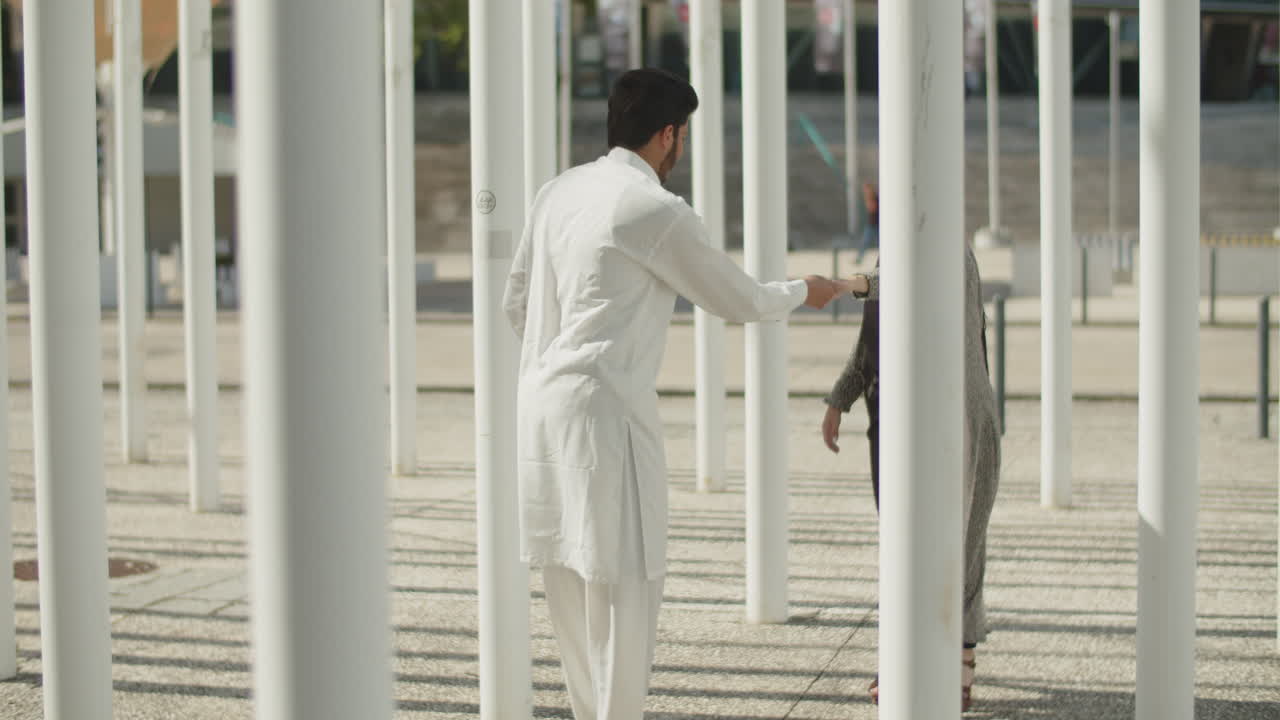 행복한 젊은 무슬림 부부는 이 나는 날 기둥 사이에서 춤을 춘다.