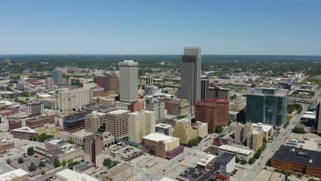 drone flies away from downtown omaha, nebraska skyscrapers in daytime