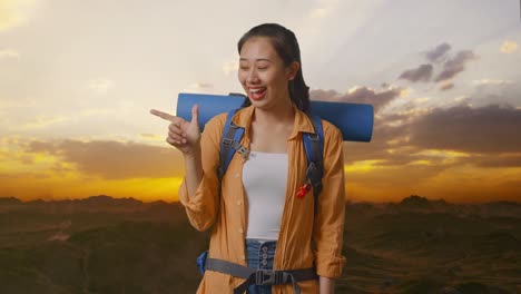 smiling woman traveler pointing to sunset view