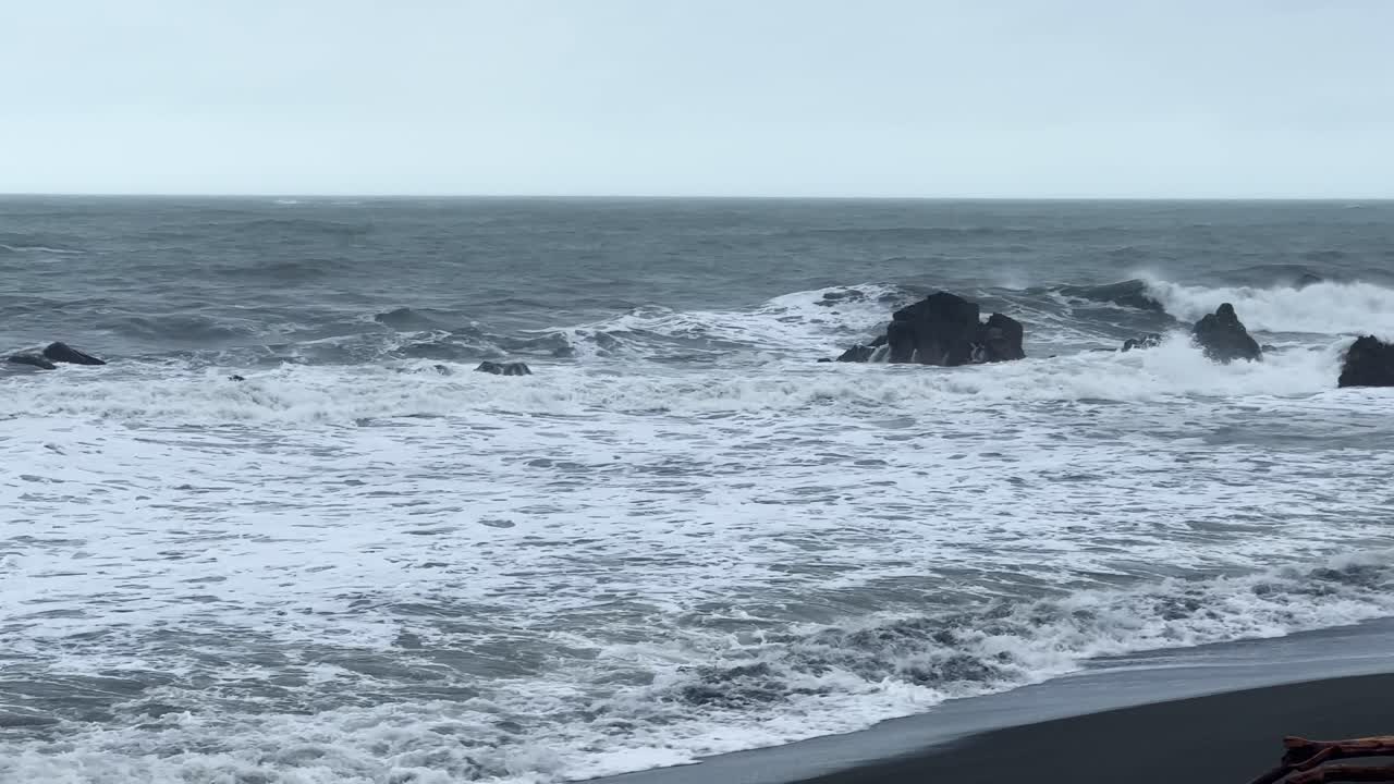 Handheld wide panning shot of strong ocean tides on a rugged beach in the Pacific Northwest. 4K at 60 FPS Slow Motion