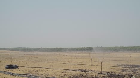 sprinkler irrigation system watering farmland in huelva, spain, wide shot