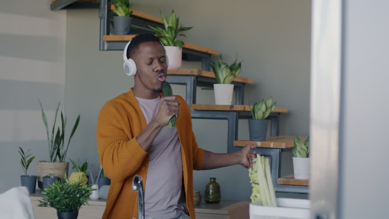 Man Singing and Dancing with a Cucumber in the Kitchen