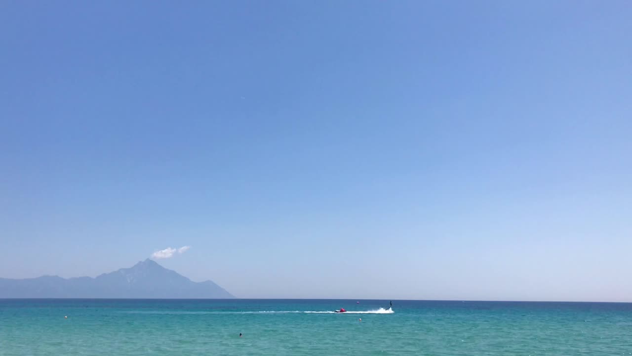 4k의 제트 스키를 타고 그리스 할키디키에서 여름철과 새로운 수상 스포츠 명소를 즐기는 두 사람