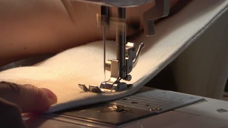 dressmaker working with sewing machine close-up