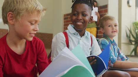 Video-De-Niños-Felices-Y-Diversos-Sosteniendo-Libros-Y-Hablando-Frente-A-La-Escuela