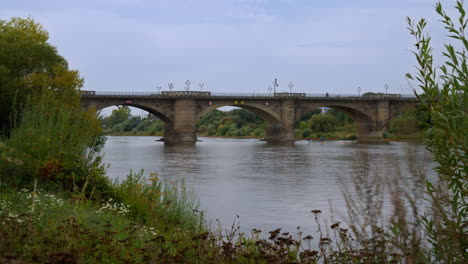 Elbbrücke-über-Die-Elbe-In-Pirna,-Zeitraffer-Des-Wasserflusses-Vom-Flussufer-Im-Herbst