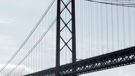 Nach-Unten-Geneigte-Aufnahme-Der-Hohen-Lissabonner-Brücke,-Brückenreflexion-über-Der-Flussoberfläche,-Portugal