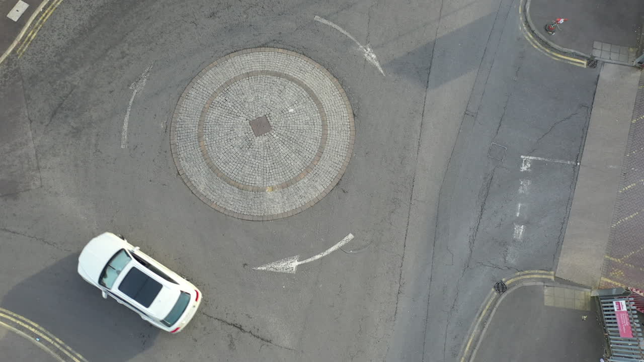 Aerial shot of white SUV driving on round about