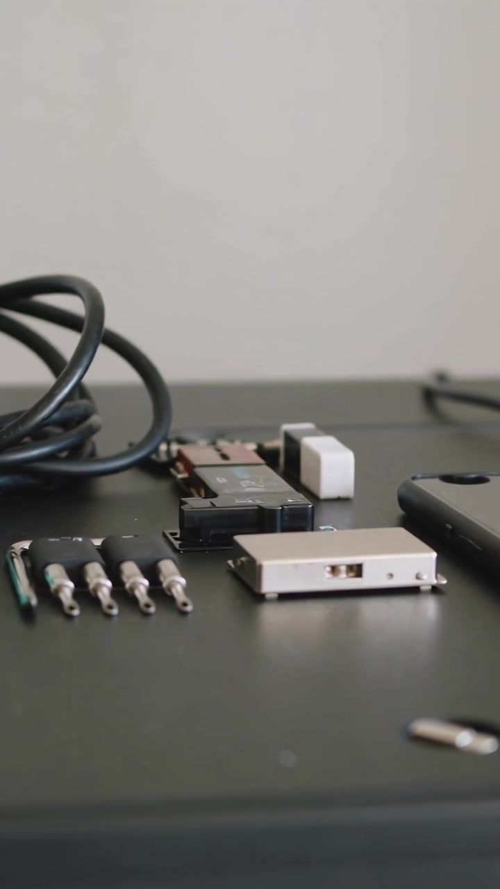 Vertical video: Panning camera moving right across desk, revealing cable and phone case for review