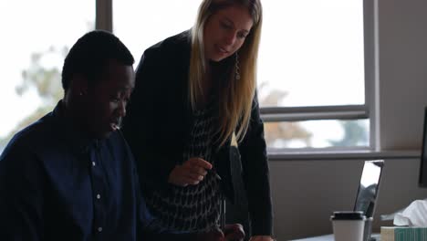 business colleagues interacting with each other at desk in office 4k