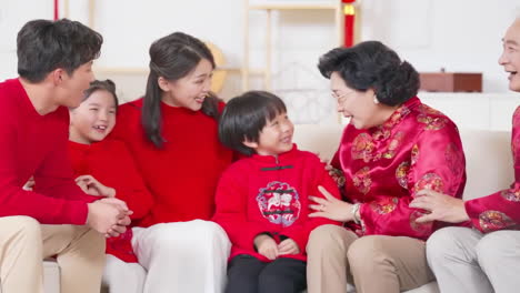 group of asia people social gathering for congratulates the new year together dinner - multi generational family sitting on the sofa chatting happily celebrating christmas holidays