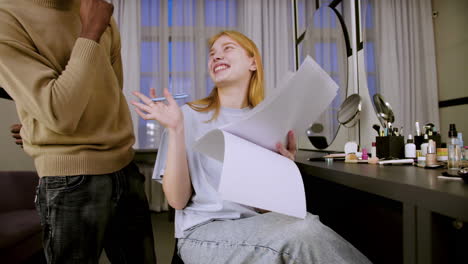 Young-woman-checking-script-on-dressing-room