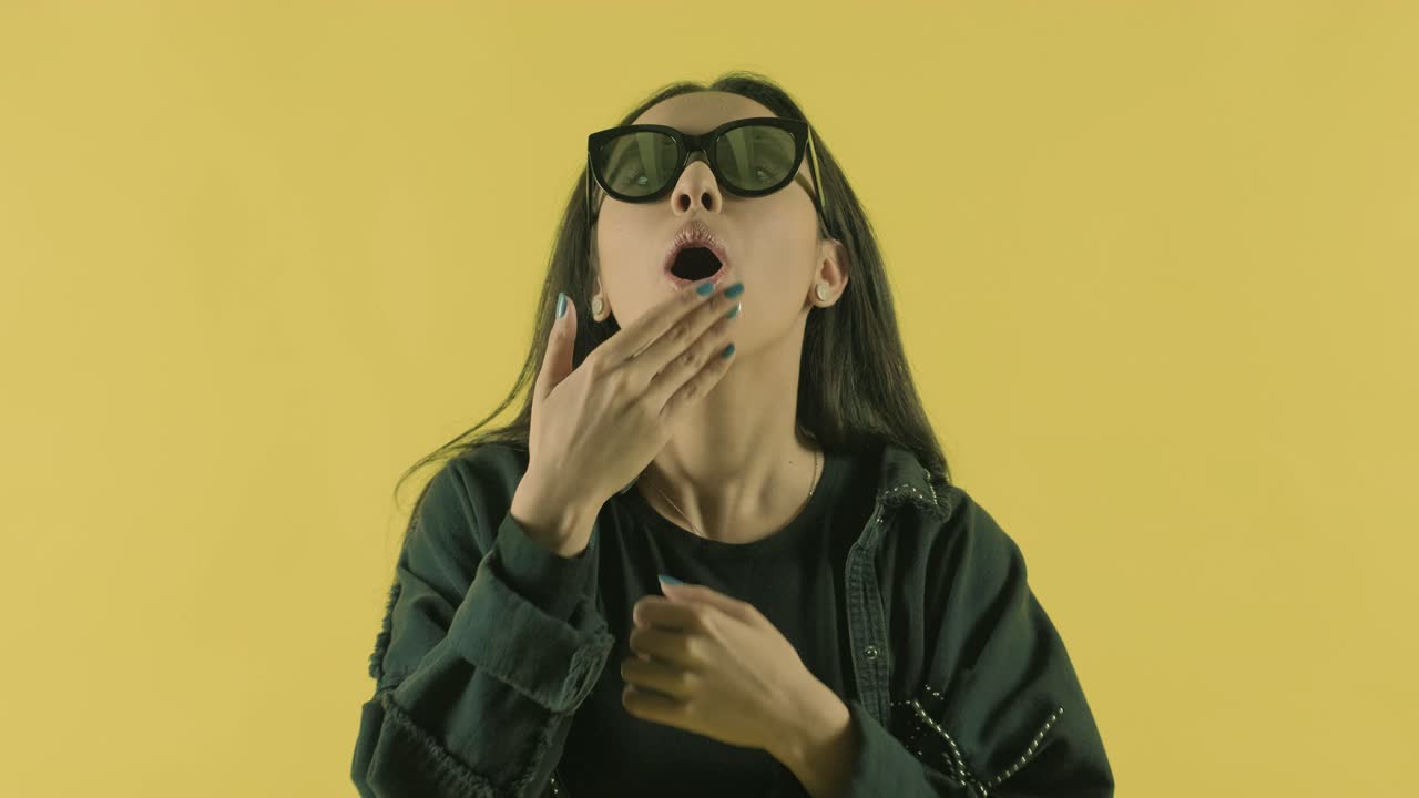 아름다운 젊은 소녀는 노란색 배경에 공기 키스를합니다