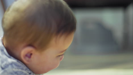 Baby-boy-smiling-on-the-ground-while-on-his-stomach-learning-how-to-crawl