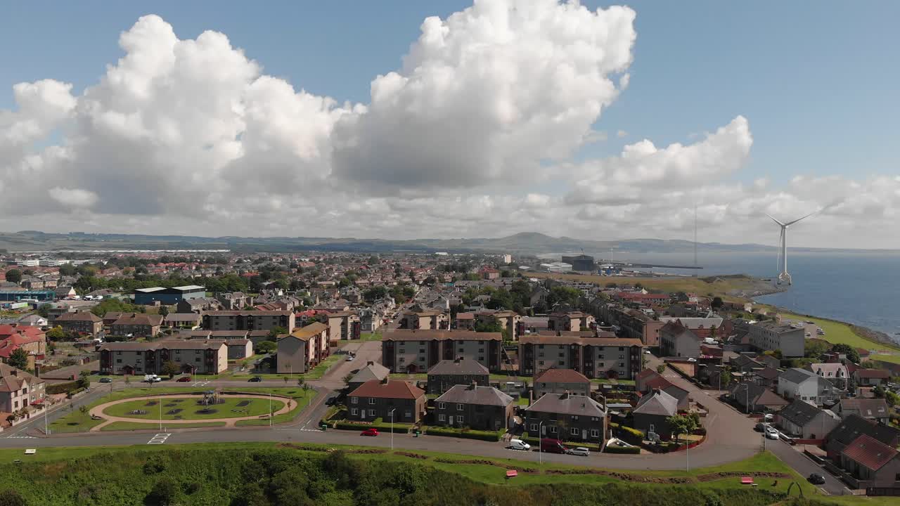vista panorámica sobre buckhaven en la costa de fife escocia con un generador eólico masivo en el parque energético