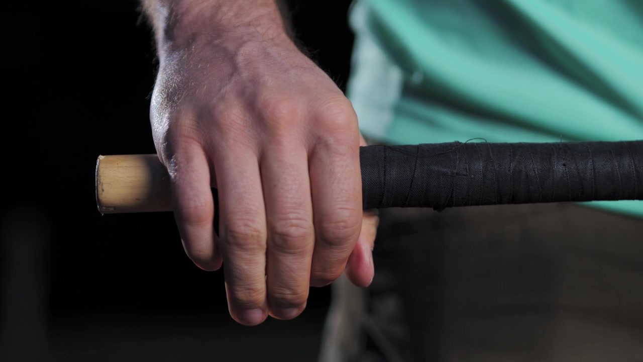 Primo piano di una mano che tiene attrezzatura sportiva con una presa potente e precisa